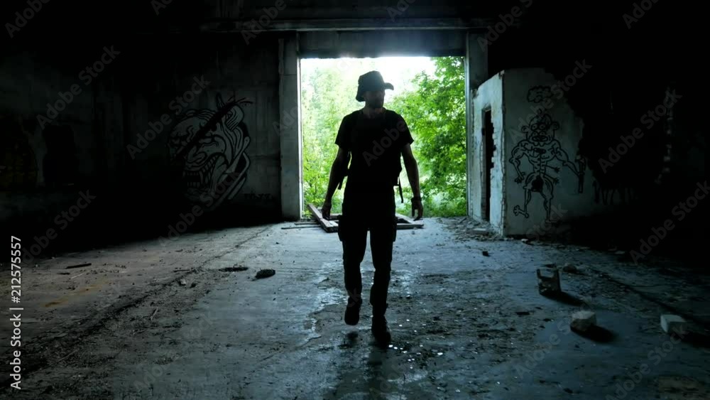 Stalker enter to the dark abandoned garage during wasteland exploring Stalker enter to the dark abandoned garage during wasteland exploring