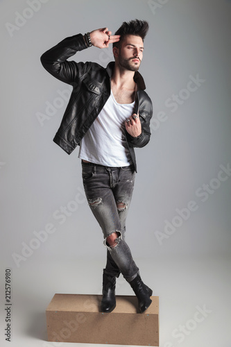 man in leather jacket posing cross-legged while standing © Viorel Sima