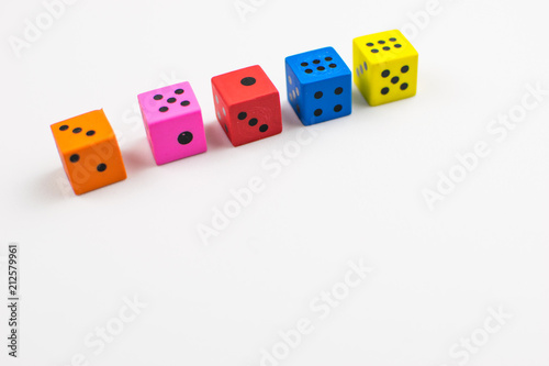 Multicolored dice cubes on a light background.