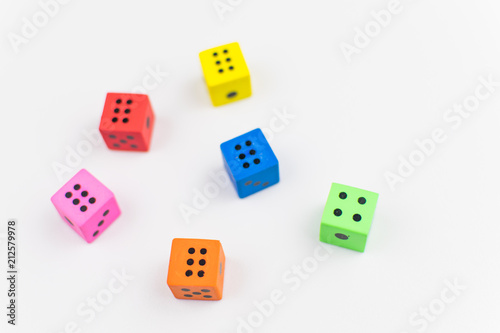 Multicolored dice cubes on a light background.