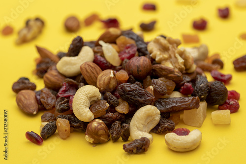 Mix of dried fruits and nuts on a yellow background