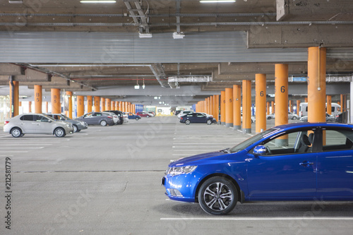 Underground parking is a large shopping center. There are not many cars. The image can be used as a background, there is room for text placement