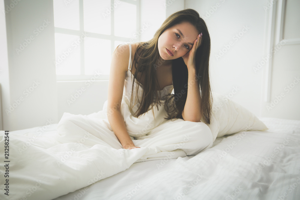 Young female feeling pain in bed.
