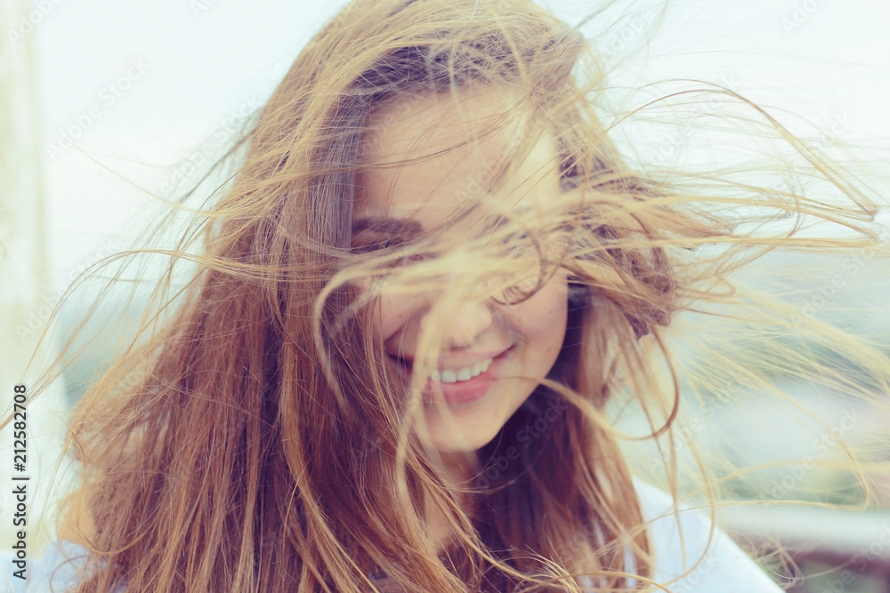 Fototapeta premium Brunette beautiful disheveled hair portrait on the beach hairstyle