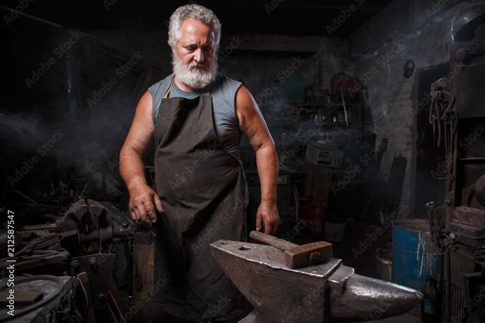 Blacksmith with brush handles the molten metal Blacksmith with brush handles the molten metal