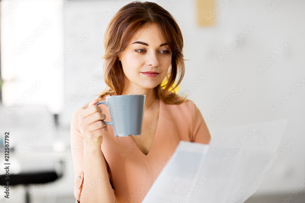business and people concept - businesswoman with papers at working office and drinking coffee business and people concept - businesswoman with papers at working office and drinking coffee