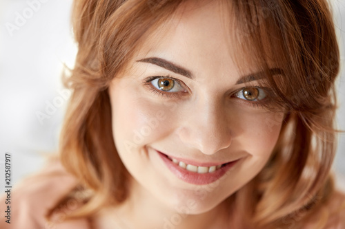 people, emotion and facial expression concept - portrait of happy smiling young woman
