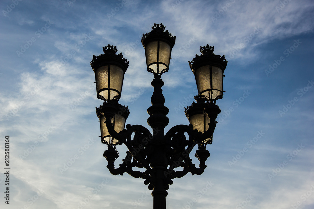 Traditional street lamp post over cloudy blue sky background in Bilbao city, north Spain. Electric company concept