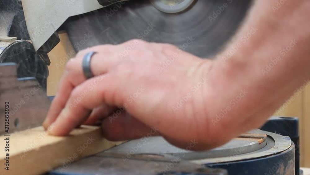 Close up of spinning blade and person holding wood in the saw. Close up of spinning blade and person holding wood in the saw.