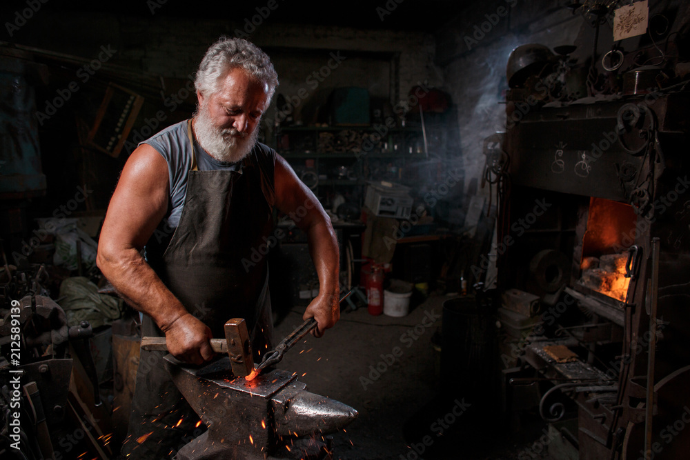 Blacksmith with brush handles the molten metal Blacksmith with brush handles the molten metal