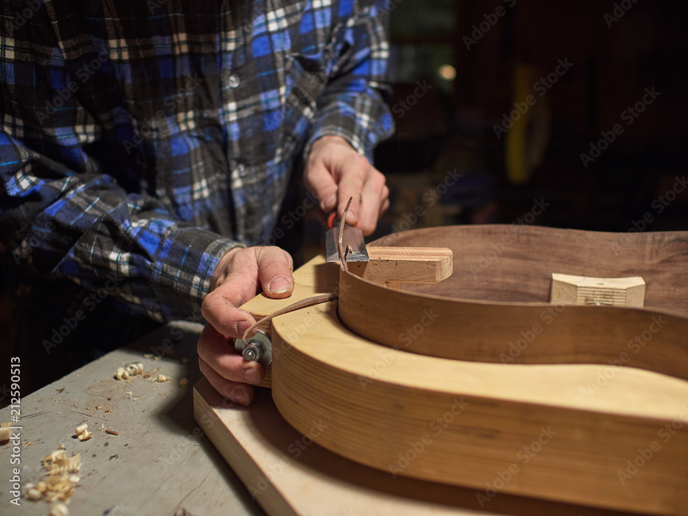 The process of making a classical guitar. Giving the sides of the guitar the right shape. The process of making a classical guitar. Giving the sides of the guitar the right shape.