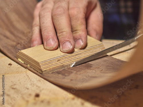 The process of making a classical guitar. Remove excess glue after gluing the tailblock. photo