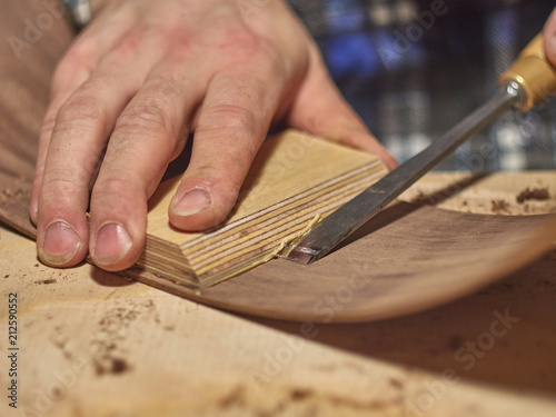 The process of making a classical guitar. Remove excess glue after gluing the tailblock. photo