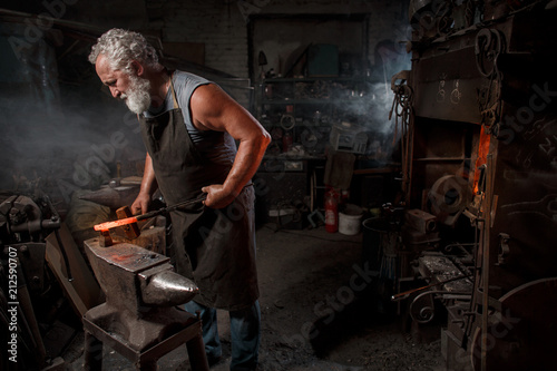 Blacksmith with brush handles the molten metal © horimono