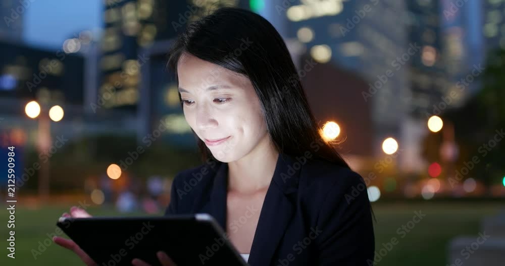 Businesswoman working on tablet computer at night Businesswoman working on tablet computer at night