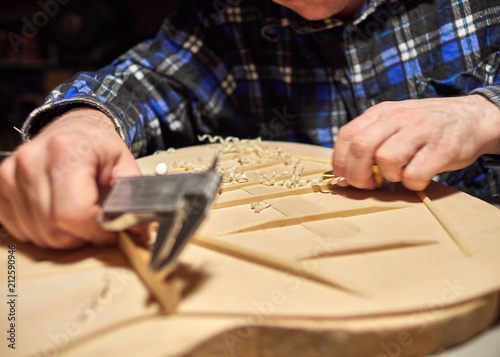 The process of making a classical guitar. Making the right shape of a brace guitar. © drouk