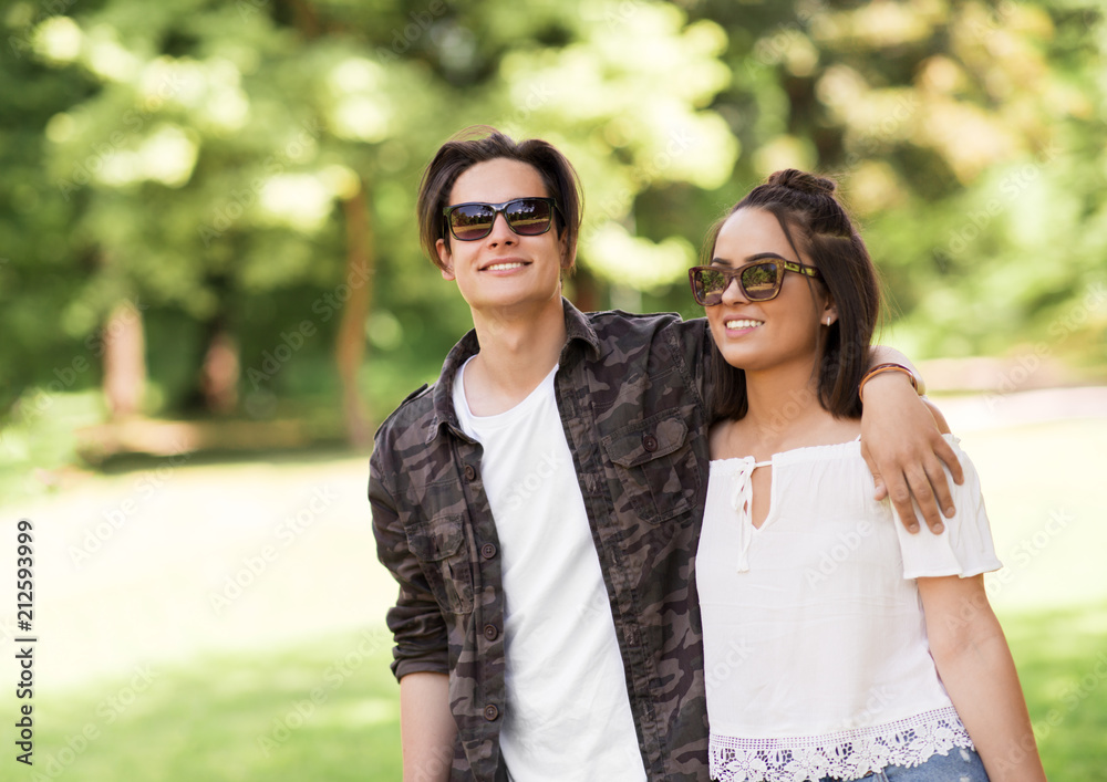 people and leisure concept - happy couple in sunglasses hugging at summer park people and leisure concept - happy couple in sunglasses hugging at summer park