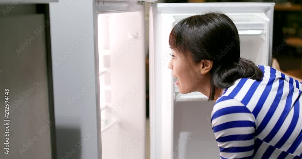 Woman open refrigerator and take out a bottle of juice Woman open refrigerator and take out a bottle of juice