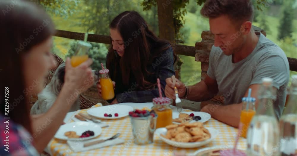 group of friends doing breakfast outdoors in a traditional countryside. shot in slow motion group of friends doing breakfast outdoors in a traditional countryside. shot in slow motion
