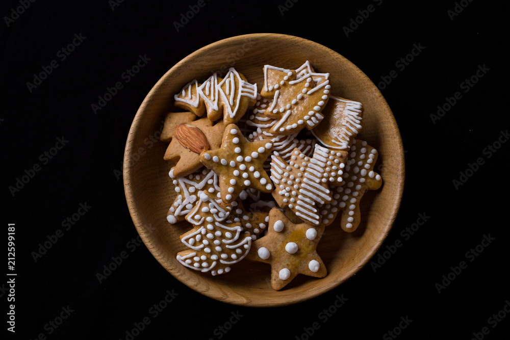 Fototapeta premium Various shapes of fresly baked ginderbread in a wooden bowl