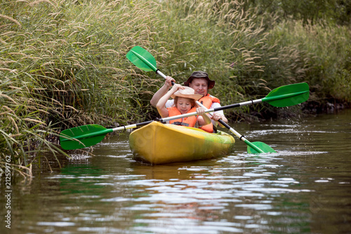 Family kayaking, father and child paddling in kayak 