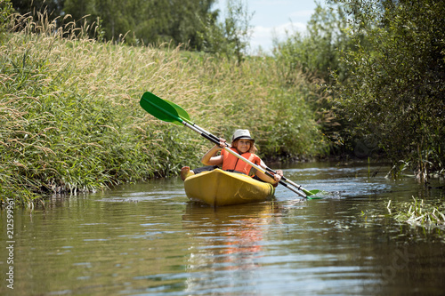 Two happy girls enjoying kayak on the river
