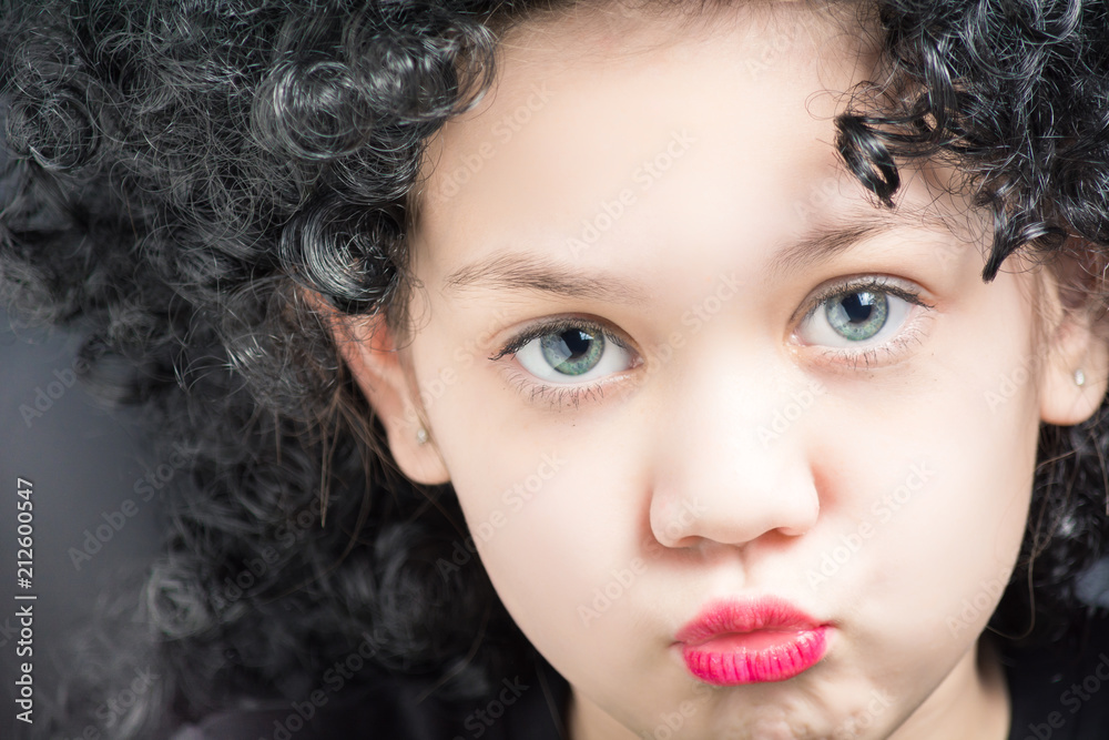 Portrait of a beautiful girl in a black curly wig Portrait of a beautiful girl in a black curly wig