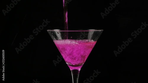 pink cocktail poured into a glasson a dark background. 4K photo