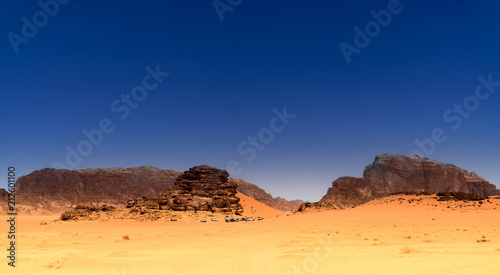 View to a camp for tourists in the desert of the nature reserve of Wadi Rum, Jordan, dark blue sky above red desert
