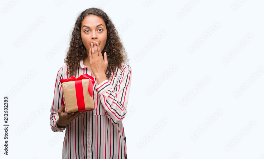 Young hispanic woman in love holding present cover mouth with hand shocked with shame for mistake, expression of fear, scared in silence, secret concept Young hispanic woman in love holding present cover mouth with hand shocked with shame for mistake, expression of fear, scared in silence, secret concept