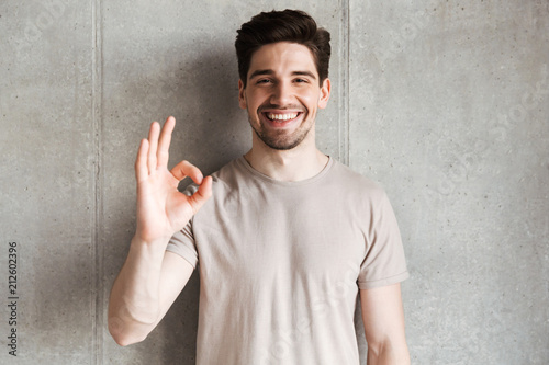 Cheerful young man showing okay gesture.