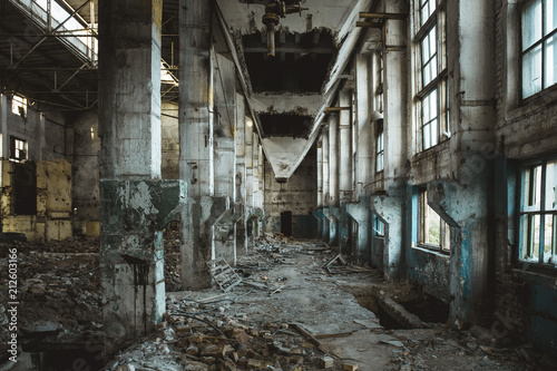 Ruins of abandoned old broken industrial factory or warehouse buildings inside after disaster, war or cataclysm © DedMityay