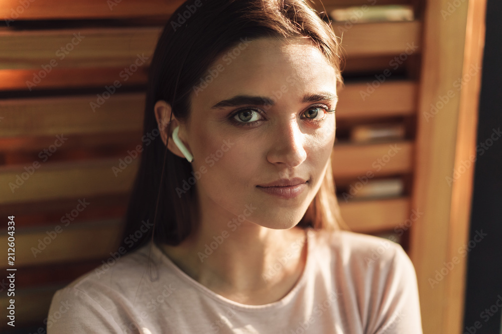 Close up of pretty young girl in wireless earphones Close up of pretty young girl in wireless earphones