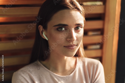 Close up of pretty young girl in wireless earphones