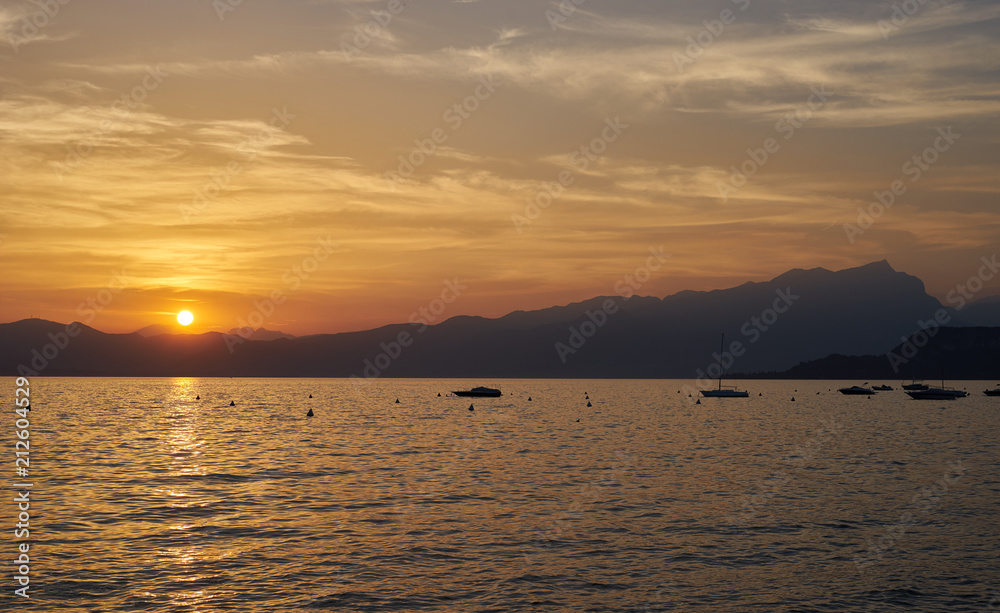 Naklejka premium Spektakularny zachód słońca z pięknym światłem w mieście Bardolino / Lake Garda we Włoszech