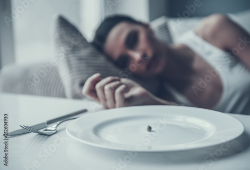 Young Woman Lying on Sofa near Plate with Pea