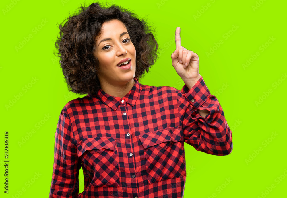 Beautiful arab woman happy and surprised cheering expressing wow gesture pointing up Beautiful arab woman happy and surprised cheering expressing wow gesture pointing up