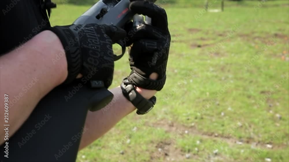 The hunter's hands charge a shotgun with cartridges The hunter's hands charge a shotgun with cartridges