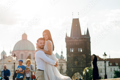 Photography Close up sensual wedding couple of groom and bride hugging while standing on the Charles bridge in Prague, Czech Republic