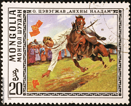 Traditional dexterity test of a horseman on mongolian postage stamp photo