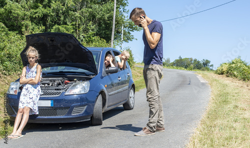 Schilderij op canvas young family with car trouble on vacation