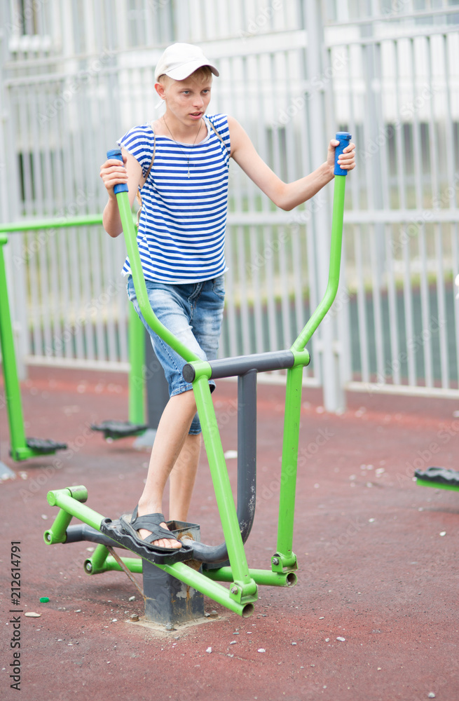 Fototapeta premium boy teenager engaged in children's exercise equipment