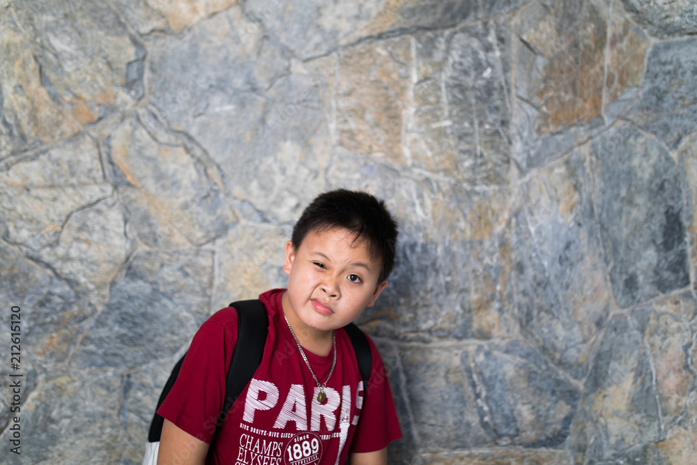 asian boy express silly face with brick wall background asian boy express silly face with brick wall background
