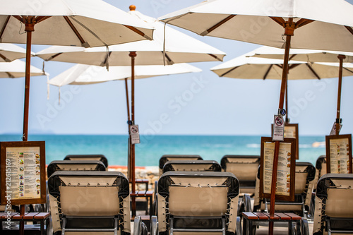 Available beach chairs in front of the beach with ocean coastline background © Soonthorn Kittikarn