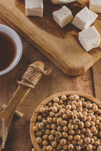 Close up of soybeans in wooden bowl. Soy products tofu and sauce  vintage tone  selective focus