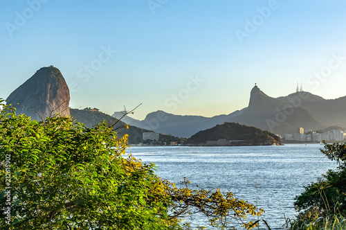 Corcovado or Cristo Redentor, Rio de Janeiro, tourist attraction, back view, a Brazil symbol, with sea and blue sky,  seen from Niteroi city, located across the Guanabara Bay. photo