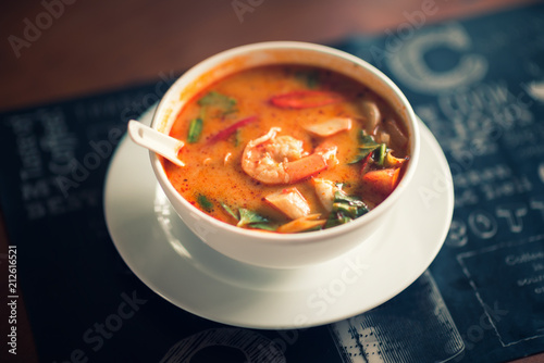 Tom Yum Goong thai hot spicy soup on wooden table,Thai popular food menu