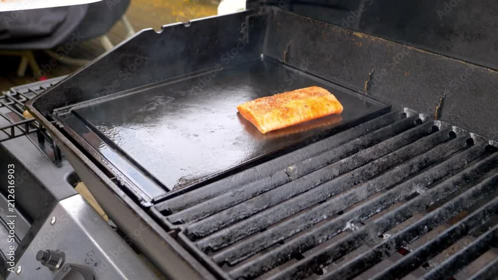 Three Salmon fillets being placed on a BBQ