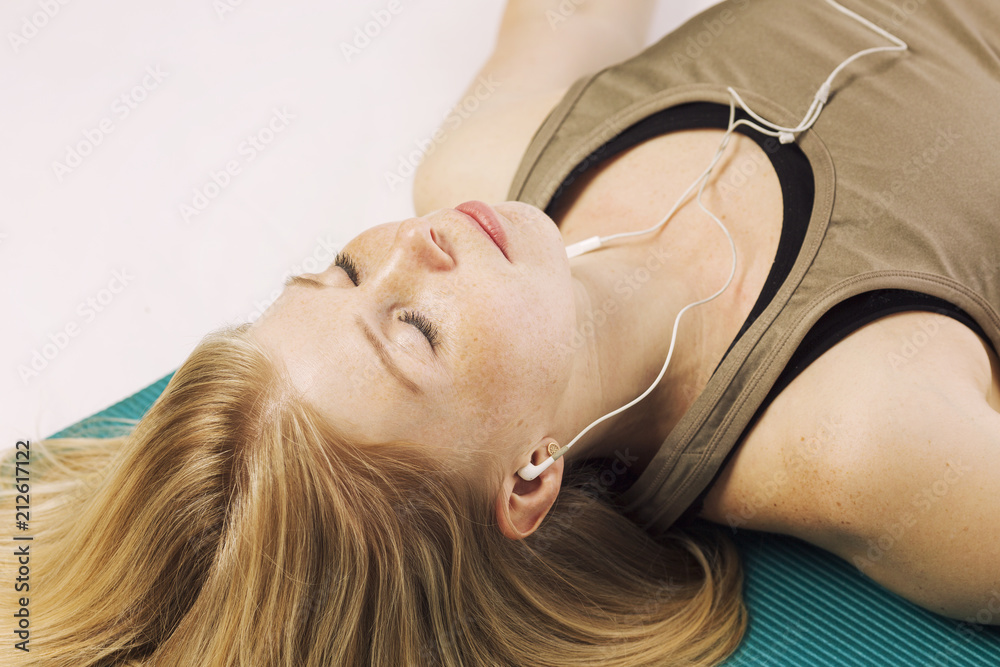 Beautiful young woman on a yoga mat relaxes, close-up Beautiful young woman on a yoga mat relaxes, close-up