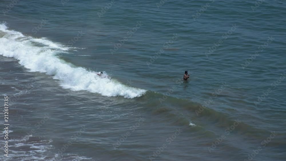 People playing with the waves of Palos Verdes, during summer time. People playing with the waves of Palos Verdes, during summer time.